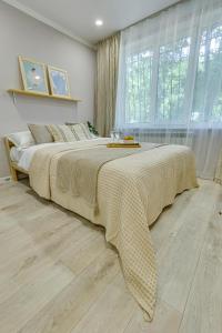 1 cama grande en un dormitorio con ventana grande en Astoria Apartments, en Almaty