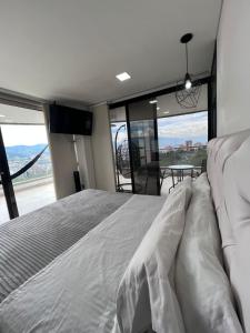 a bedroom with a bed and a large window at Large Apartment High Views and Balcony in Medellín