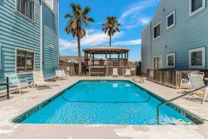 a swimming pool next to a house with a gazebo at Leeward 802 in Corpus Christi