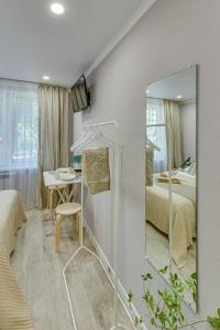 - une chambre avec un miroir, un lit et une table dans l'établissement Astoria Apartments, à Almaty