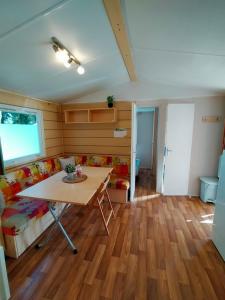 ein Wohnzimmer mit Tisch und Couch in der Unterkunft Camping Le Ried *** Mobil Home Cosy 3 chambres Proche Europa Park Rulantica in Boofzheim + 9 Fotos