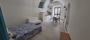 Residenza Giannini a Rodi Garganico في رودي غارغانيكو: غرفة نوم بسرير ومطبخ مع طاولة