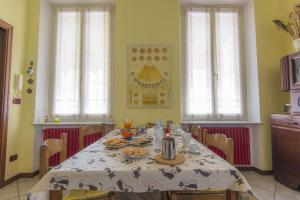 a dining room with a table and chairs and windows at B&B - Il Portichetto in Asti