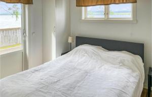a white bed in a bedroom with two windows at Beautiful Home In Grythyttan With 1 Bedrooms in Grythyttan