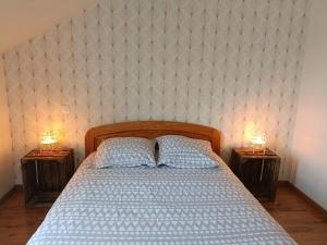 a bedroom with a bed and two nightstands with lamps at La Clair'fontaine in Clairvaux