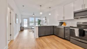 a large kitchen with white cabinets and a wooden floor at Beltline 1 bdrm Apt in Atlanta