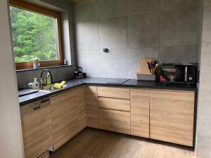 a kitchen with a sink and a counter with a window at WALDHAUS HIRSCH Bungalow only for you self check in in Pörtschach am Wörthersee