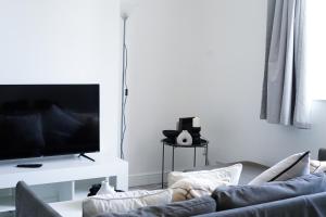 a living room with a couch and a flat screen tv at Brighton City Centre Apartment with Two Parking Spaces in Brighton & Hove