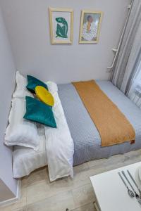 - une chambre avec un lit doté d'oreillers bleus et blancs dans l'établissement Astoria Apartments, à Almaty