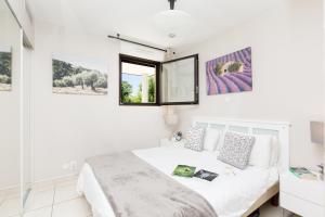 a white bedroom with a bed and a mirror at Luxury 3 pièce Garden Apartment in Cannes Marina in Mandelieu-La Napoule +19 photos