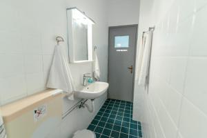 a white bathroom with a sink and a toilet at Kuburno House - Spacious - close to the beach apartment in Kos Town