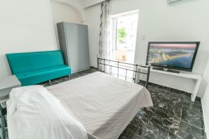 a living room with a couch and a tv at Kuburno House - Spacious - close to the beach apartment in Kos Town