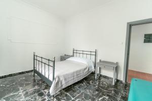 a bedroom with a metal bed and a table at Kuburno House - Spacious - close to the beach apartment in Kos Town