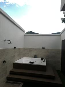 a bath tub sitting in the corner of a bathroom at Ayenda Apartahotel Noche de Luna in Cali