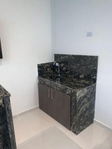 a bathroom with a black marble counter and a sink at Ayenda Apartahotel Noche de Luna in Cali