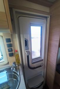 a bathroom with a sink and a window in an airplane at Achziv Beach אכזיב חף in Liman