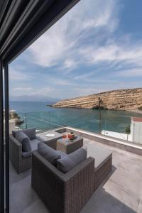 un patio con sofás y vistas al océano. en Aphrodite Luxury Accommodation en Mátala