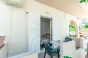 un patio con tavolo e 2 sedie verdi di Kuburno House - Spacious - close to the beach apartment a Città di Kos