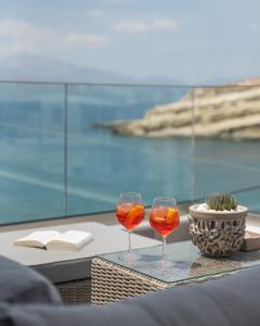 dos copas de vino sentadas sobre una mesa en Aphrodite Luxury Accommodation en Mátala