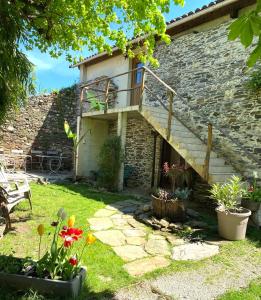 una casa de piedra con una escalera en un patio en Maison d'Hôtes Hameau de Taur, en Villefranche-dʼAlbigeois