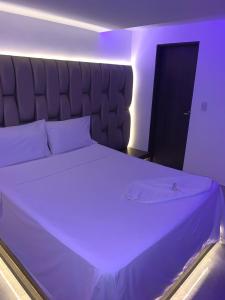 カリにあるAyenda Apartahotel Noche de Lunaの紫色の照明が備わる客室の大型ベッド1台