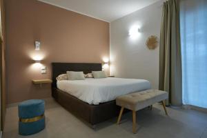 a bedroom with a large bed with a blue stool at B&B Il Girasole in Capo dʼOrlando