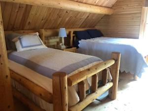 um quarto com uma cama num chalé de madeira em Beddington Lake Log Cabin 
