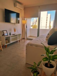 1 dormitorio con 1 cama y TV de pantalla plana en Excelente Apartamento Centro Opcional Cochera by Lofter en La Plata