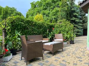 two wicker chairs and a table on a patio at Apartament Maria in Krakow