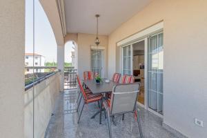 een patio met een tafel en stoelen op een balkon bij Apartments Covic in Antonci