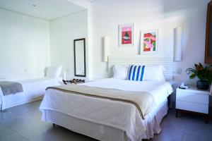 Un dormitorio blanco con una gran cama blanca. en Hotel Recanto da Cachoeira, en Socorro