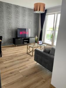 sala de estar con sofá y TV en Apartament Drewnowska przy Manufakturze en Lodz