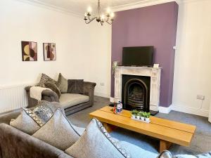 a living room with a couch and a fireplace at 3 Queen Alexandra Road in North Shields