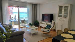 un salon avec un canapé et une télévision dans l'établissement Garden Beach Apartment, à Torrevieja