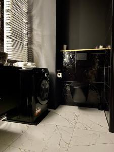 Baño con cámara en una habitación negra en Apartament Drewnowska przy Manufakturze en Lodz