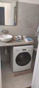 eine Waschmaschine im Bad mit Waschbecken in der Unterkunft Appartamento 2 del Vecchio Convento in Orino + 2 Fotos