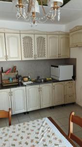 cocina con armarios blancos y microondas blanco en Вила Верона, en Kavarna