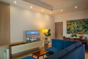 a living room with a blue couch and a flat screen tv at Unico Gravina in Gravina di Catania