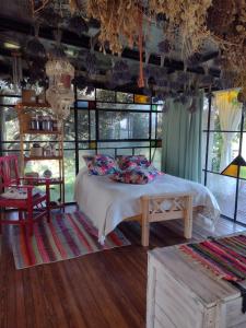 Schlafzimmer mit einem Bett, einem Tisch und Fenstern in der Unterkunft LOFT DE MONTAÑA -LaS RABONAS - PISCINA EXCLUSIVA in Las Rabonas