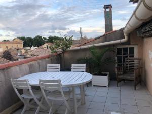 uma mesa branca e cadeiras numa varanda em Terrasse tropézienne centre Nimes em Nîmes