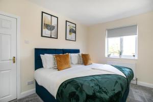 a bedroom with a blue and white bed and a window at Modern & Spacious House In Derby in Derby