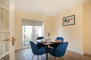 a dining room with a table and blue chairs at Modern & Spacious House In Derby in Derby