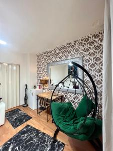 een woonkamer met een groene stoel voor een spiegel bij 1+1 İstiklal caddesine 100 metre in Istanbul
