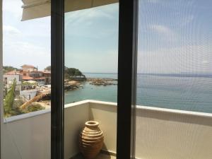 un balcone con vista sull'oceano e un vaso di Filanthi CostaS a Stoupa