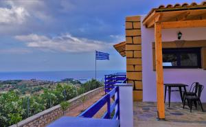 a balcony of a house with a table and a flag at Villa Leonardo in Archangelos