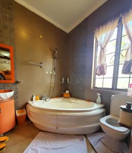 a large bathroom with a tub and a toilet at Edaala Comfort - B&B in Nairobi