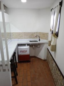 a kitchen with a counter with a cocacola sink at Pousada Chez Loran lagoa do paraiso in Jijoca de Jericoacoara