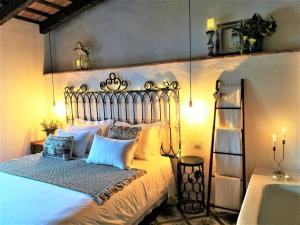 Schlafzimmer mit einem Bett mit blauen und weißen Kissen in der Unterkunft Casa Romántica con Sauna privada Eternal Rural in Jimena de la Frontera