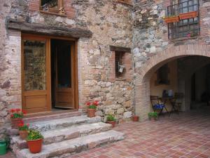 una entrada a un edificio de piedra con macetas en Bed and Breakfast Casanova de Sant Miquel, en Aiguafreda
