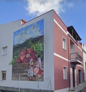 une peinture murale de filles sur le côté d'un bâtiment dans l'établissement Il melograno, à Usini
